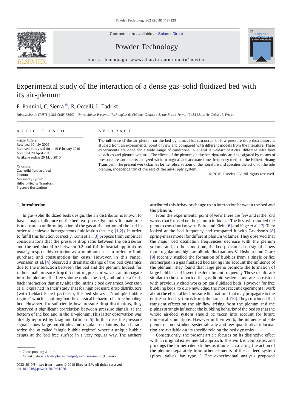 Experimental study of the interaction of a dense gas–solid fluidized bed with its air-plenum