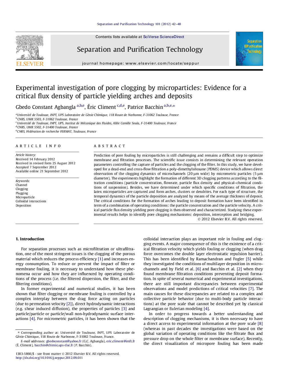 Experimental investigation of pore clogging by microparticles: Evidence for a critical flux density of particle yielding arches and deposits